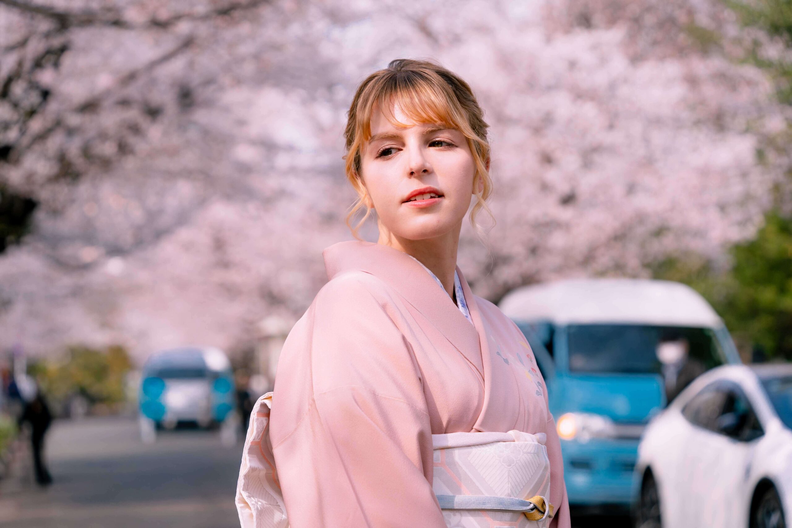 Woman in traditional kimono surrounded by cherry blossoms in Tokyo