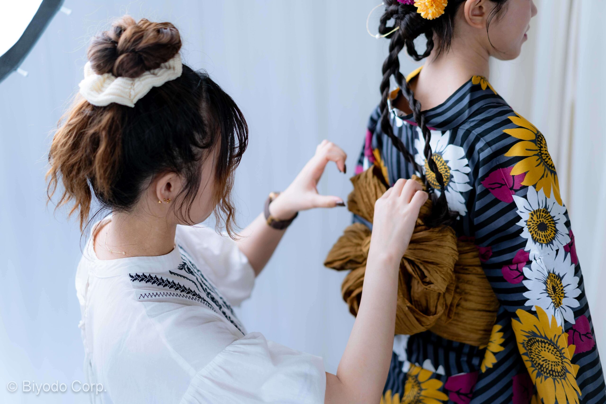 Hair and makeup artist styling yukata and updo hairstyle for a photoshoot in Tokyo