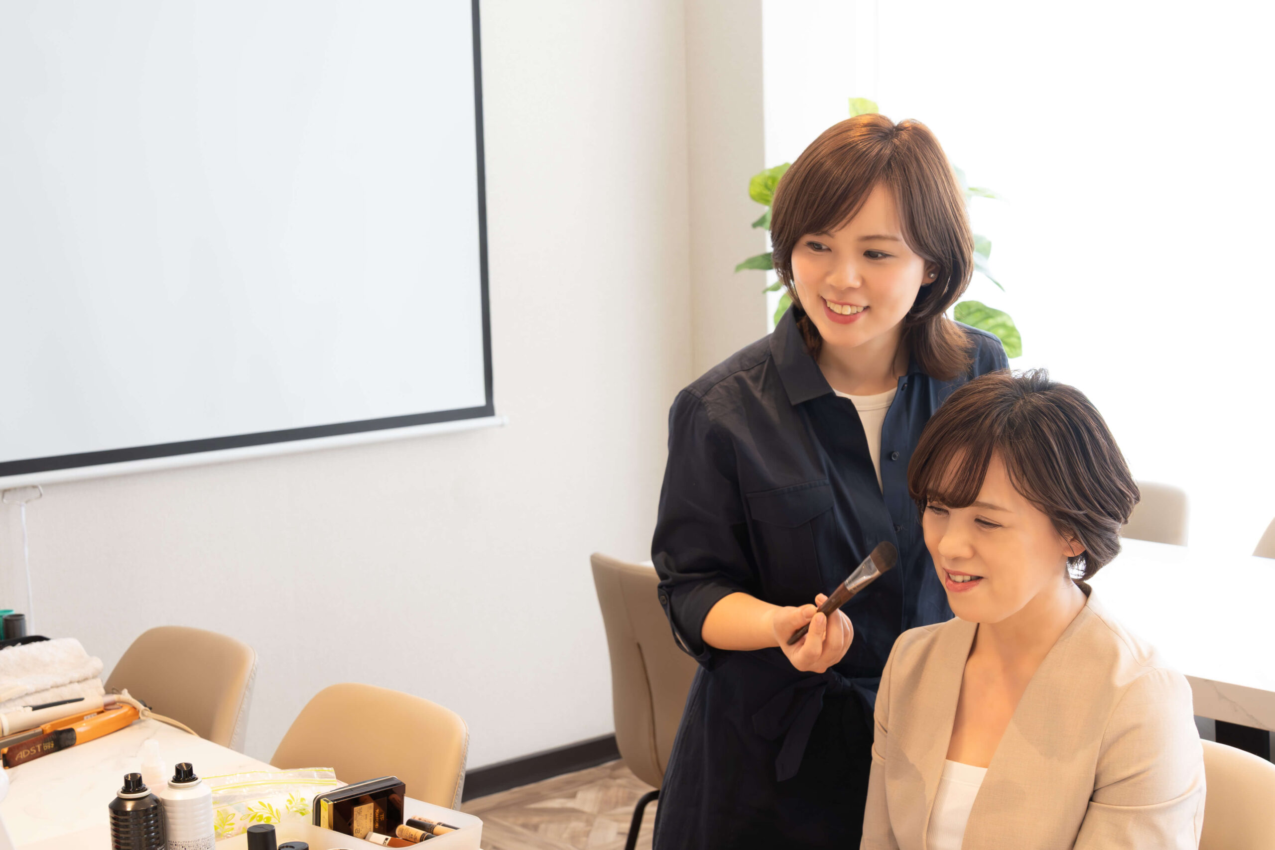 会議室で経営者にメイクを施す様子